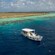Snorkelers swimming near a boat and an island